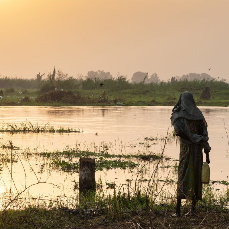 Mundari woman observing the White Nile after sunrise, Terekeka, South Sudan